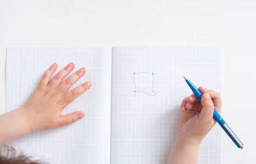 The child connects the shape points in the notebook