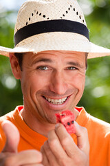 portrait d'un bel homme souriant avec de la pastèque
