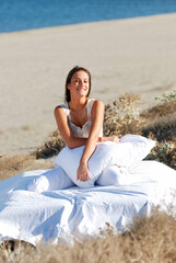 Fototapeta na wymiar happy beautiful girl outdoor on the sand in white bed