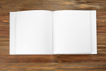 Blank pages of opened book on wooden background