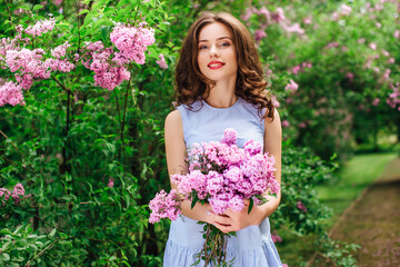 Young girl stand at park background with bouquet of flowers