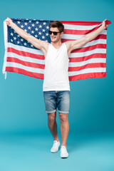 Handsome man holding USA flag. Looking aside.