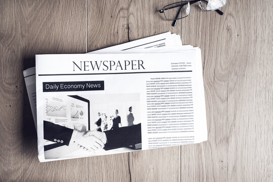Newspaper with eyeglasses on table