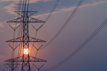 High voltage pole clouds and the sun are falling, Electricity transmission pole.