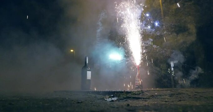A dazzling spectacle of fireworks. Sparks fly as a man ignites another round. 
