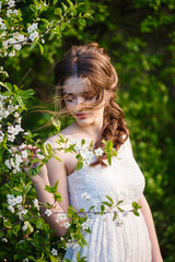 Beautiful woman in a spring garden under a blossoming tree