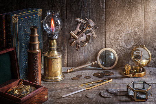 Exploration and nautical theme grunge background. Compass, telescope, sextant, coin, divider and old book on wood desk.