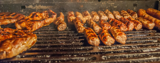 mixed meat on barbecue grill. sausages, minced meat and steaks