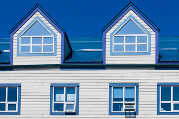 Wooden frame house blue metal roof dormer windows