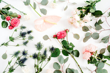 Beautiful flowers: bombastic roses, blue eringium, pink anthurium flower, eucalyptus branches on white background. Flat lay, top view. Floral lifestyle composition.