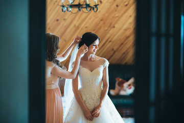 The bridesmaid corrects a bride's hairdo
