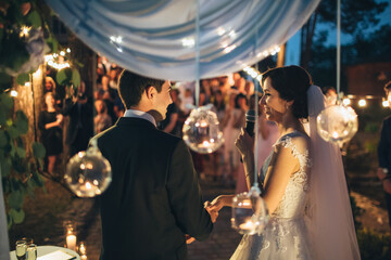 The bride keeps a microphone and speeking to her groom