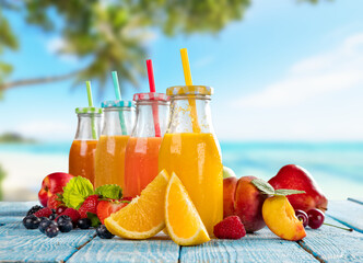Fresh smoothie drinks placed on wooden planks, blur beach on background