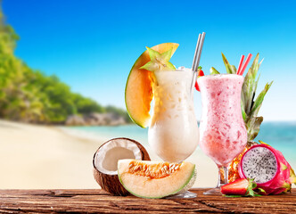 Fresh fruit drinks placed on wooden planks, blur beach on background