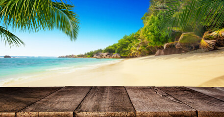 Tropical beach with wooden table, summer holiday background.