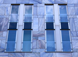 Facade of modern building with blue marble tiles and panes