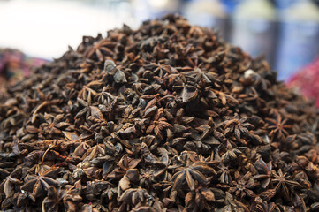 Stack of star anise seeds, the crop of Illicium verum plant, with extensive culinary and medical use in Asian and African countries at the medina herbal markets in Marrakesh, Morocco.