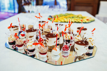 Glasses with tiramissu served on large mirror tray