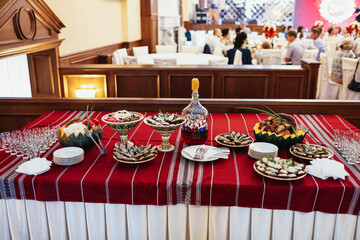 Plates with snacks stand served on red table in the restaurant