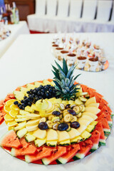 Slices of watermelon, pineapple and grape served on a large tray
