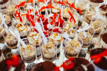 Glasses with cold cream desserts stand served on round mirror tray