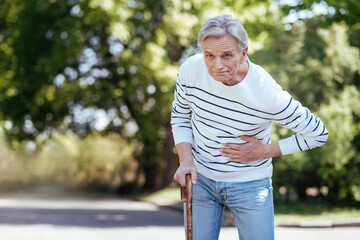 Puzzled pensioner having sudden ache in chest outdoors