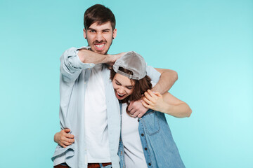 Fototapeta premium Joyful man playing and torturing his displeased young sister
