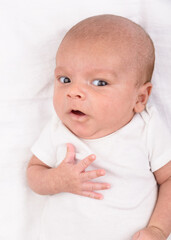 Newborn baby on white sheet