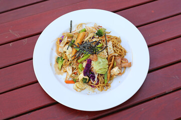 Japanese yakisoba noodles in white plate on wood table.