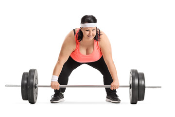Fototapeta na wymiar Overweight woman preparing to lift a barbell