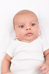 Newborn baby on white sheet