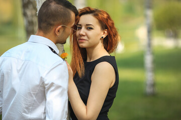 Fototapeta premium Couple in love. Handsome guy and pretty girl posing in the birch grove in the village.