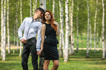 Fototapeta premium Couple in love. Handsome guy and pretty girl posing in the birch grove in the village.