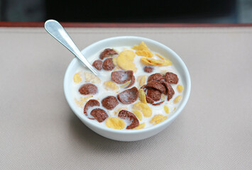 Cornflakes cereal and milk in a bowl. Morning breakfast.