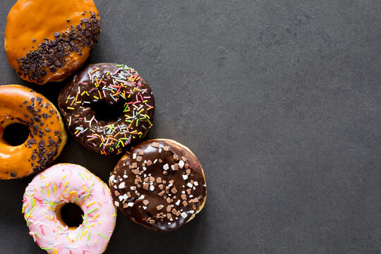 Glazed donuts on dark background. Table top view and copy space