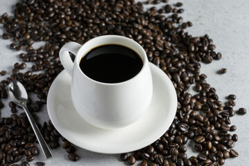White glass of coffee with coffee bean on a stone table.