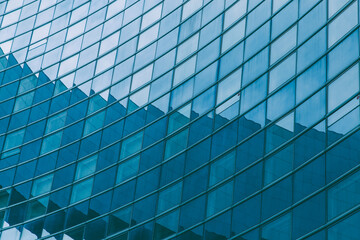 Fototapeta na wymiar Modern blue glass wall of skyscraper. Business building, office center. Abstract architecture, fragment of modern urban geometry. Background lines