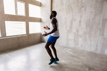 Obraz na płótnie Canvas Well-built african guy making warm-up exercises