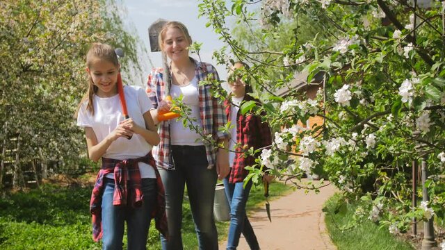 4K footage of happy family walking with gardening tools after working in garden