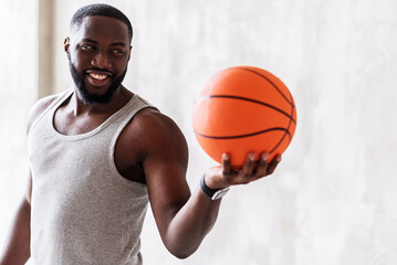 Joyful bearded handsome athlete offering others to practice ball game