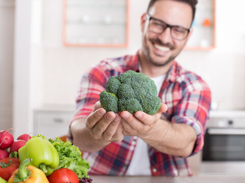 Man showing vegetables in kitchen