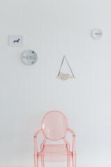 White Interior wall with pink ghost chair