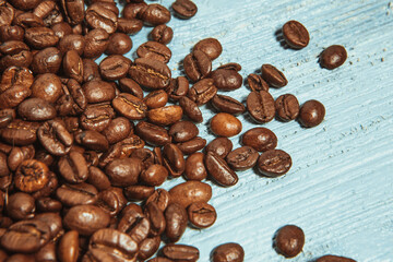 Dark many roasted coffee beans on blue background
