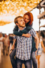 Happy couple embracing in the evening on a light garlands