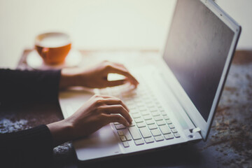 Hand of woman working with her Laptop and Coffee by the side