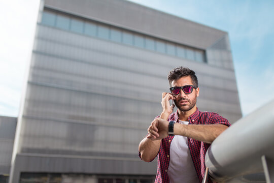 Man talking phone and checking time