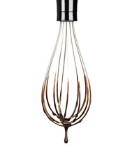 Cookery wire whisk with splashing chocolate isolated on white background with clipping path. Chocolate drop