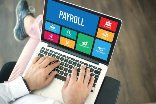 People Using Laptop In An Office And PAYROLL Concept On Screen