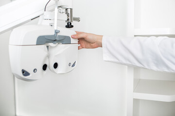 optometrist adjusts vision equipment, phoropter. Ophthalmological equipment for vision testing