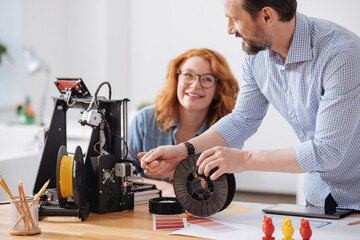 Professional experienced designer loading filament into 3d printer